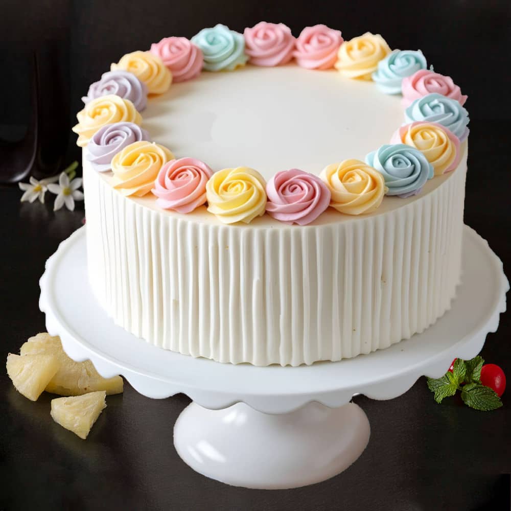 pastel rose vanilla cake Pastel rose vanilla cake with colorful floral icing decorations, available for birthday and anniversary delivery in Guwahati.