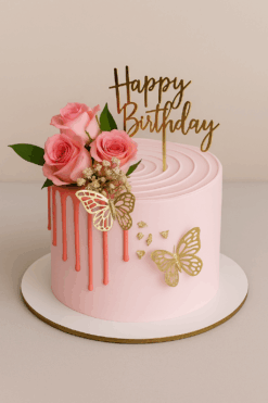 Elegant pink rose birthday cake with gold butterfly decorations, pink drip design, and “Happy Birthday” topper – perfect for celebrations in Guwahati.