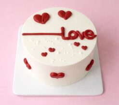 Love theme vanilla cake with red heart design for couples in Guwahati